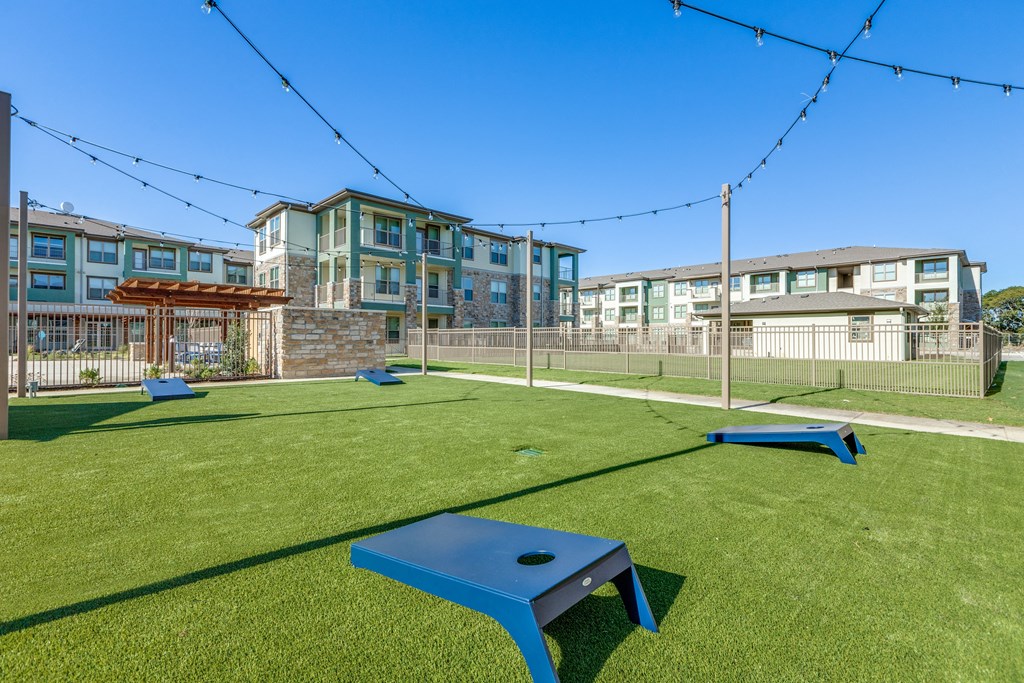 a playground with a table and benches in front of an apartment building