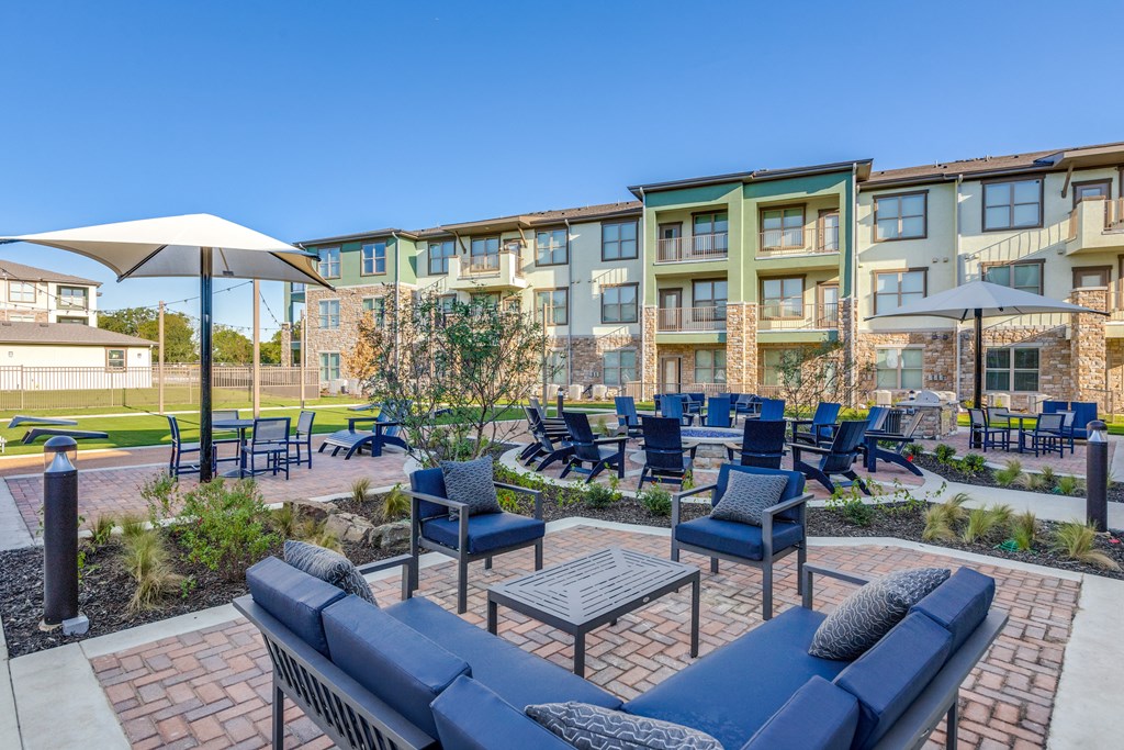 an outdoor lounge area with tables and chairs at the preserve at polk apartments