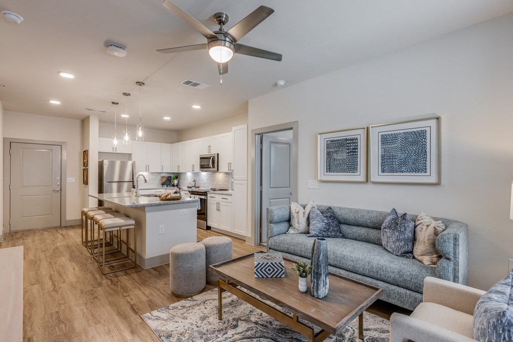 an open living room and kitchen with a ceiling fan