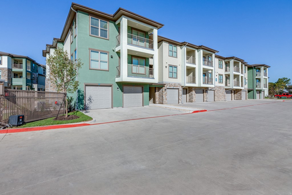 an empty parking lot in front of an apartment building
