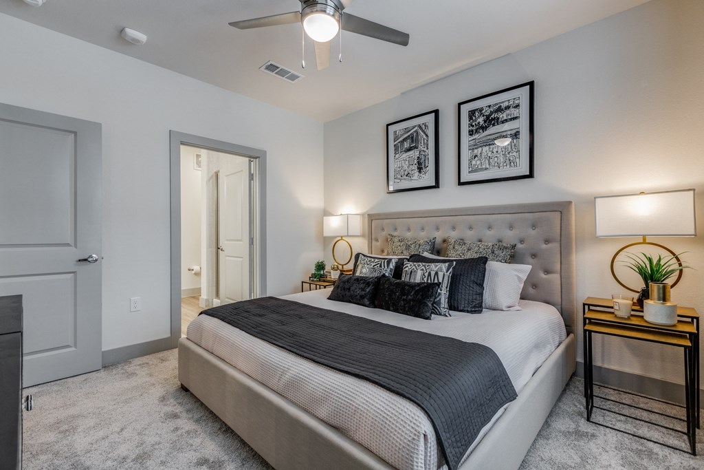 a bedroom with a large bed and a ceiling fan