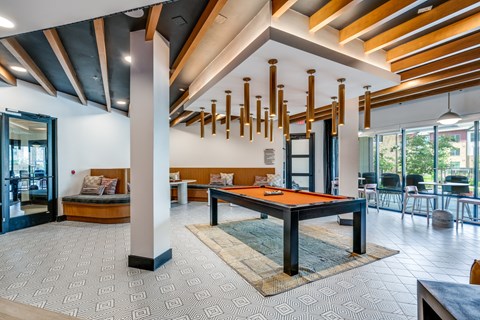 A room with a pool table and a bench.