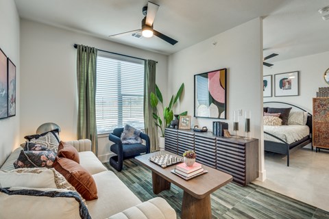 A living room with a couch, chair, and a table with a plant on it.