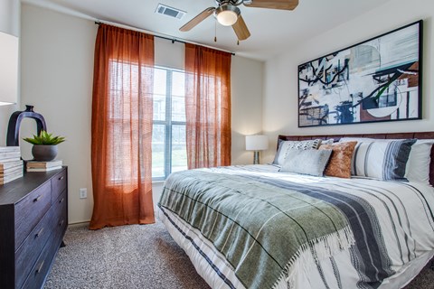 a bedroom with a bed and a window and a ceiling fan