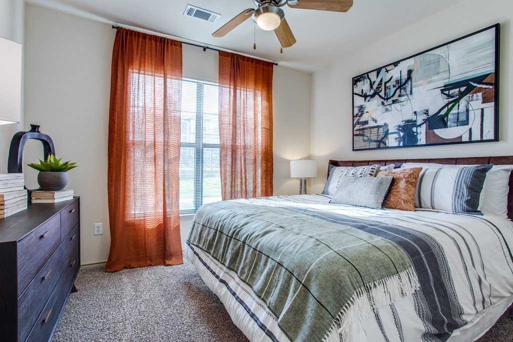 a bedroom with a bed and a window and a ceiling fan