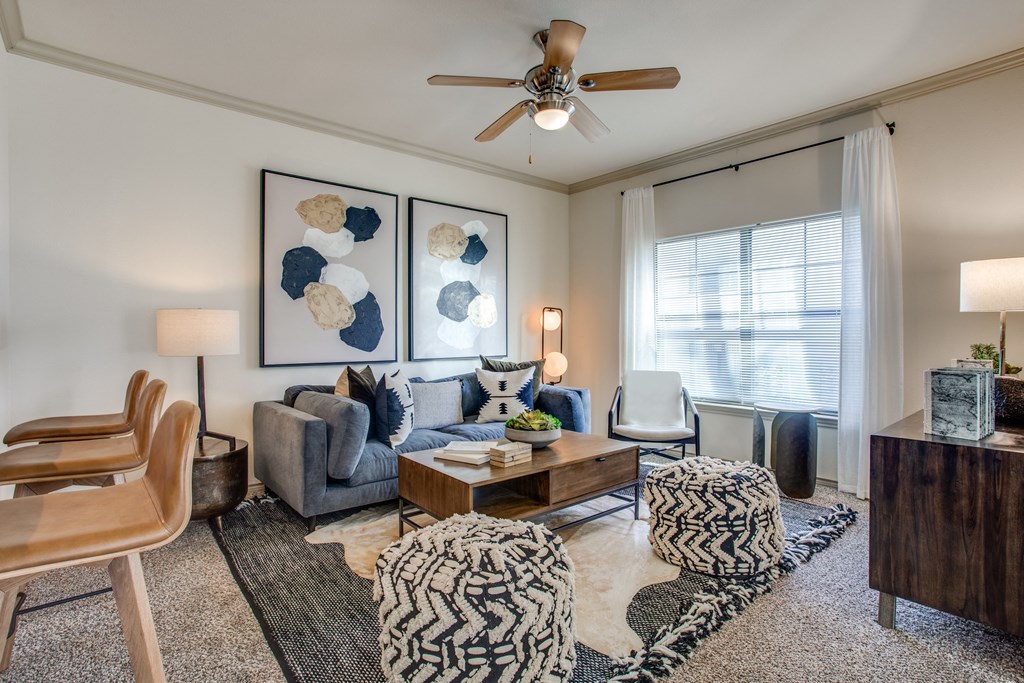 an open living room with a ceiling fan and a large window