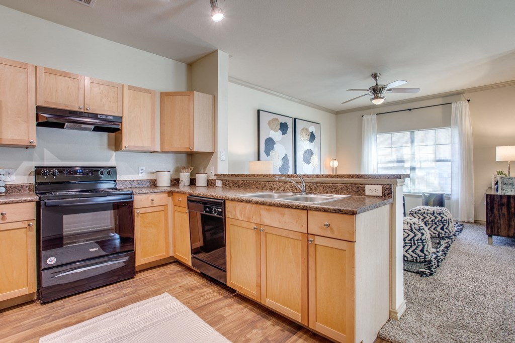 an open kitchen with wooden cabinets and a counter top