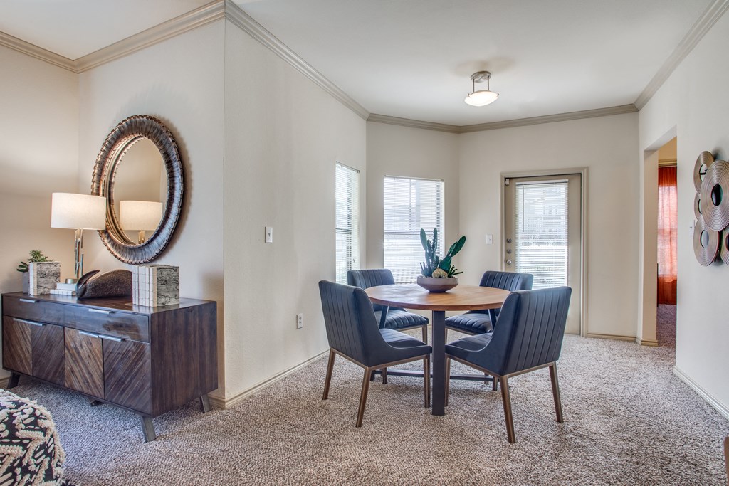 an empty living room with a dining room table and chairs