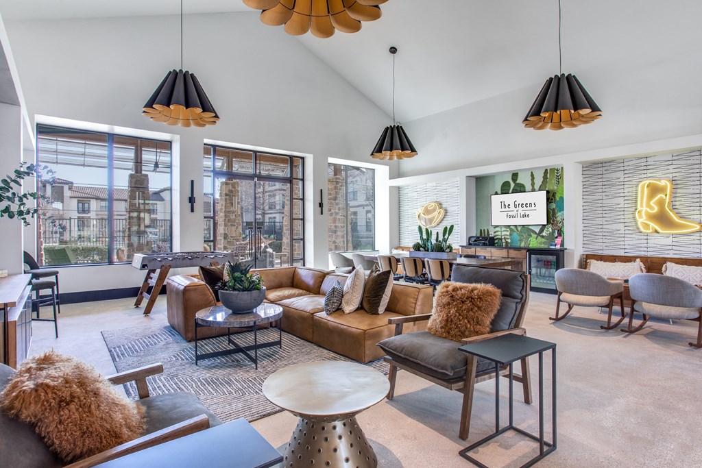 a living room with couches and chairs and large windows