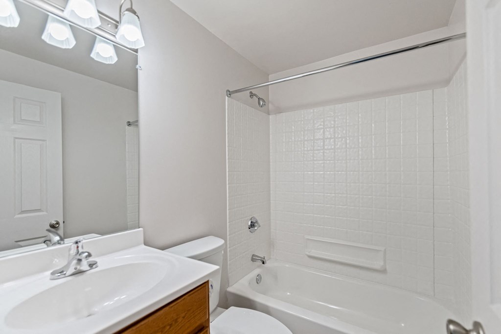 a bathroom with a white tub and a sink and a toilet