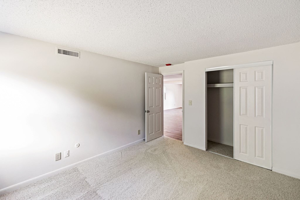 an empty living room with a door open to a hallway