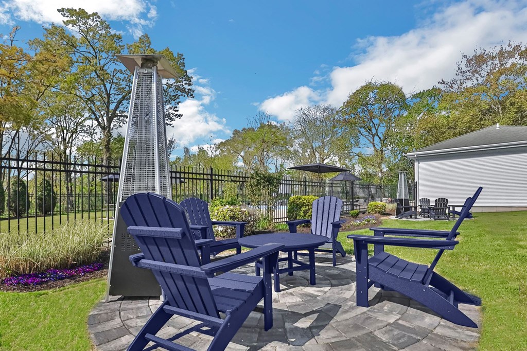 A blue chair set sits in a yard.