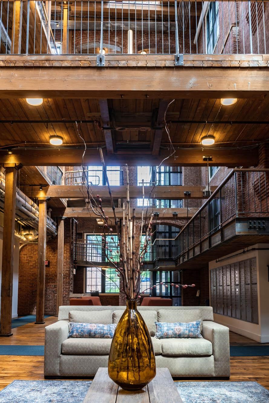 the lobby of a building with a couch and a vase