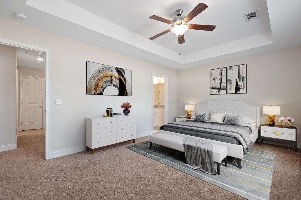 Omnia at Richmond Hill Townhomes in Georgia photo of a spacious bedroom with a bed and a ceiling fan.