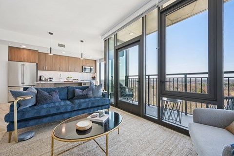 A modern living room with a glass table and a blue couch.