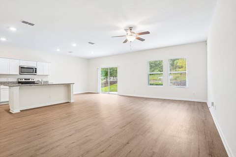 A spacious room with a ceiling fan and wooden flooring.