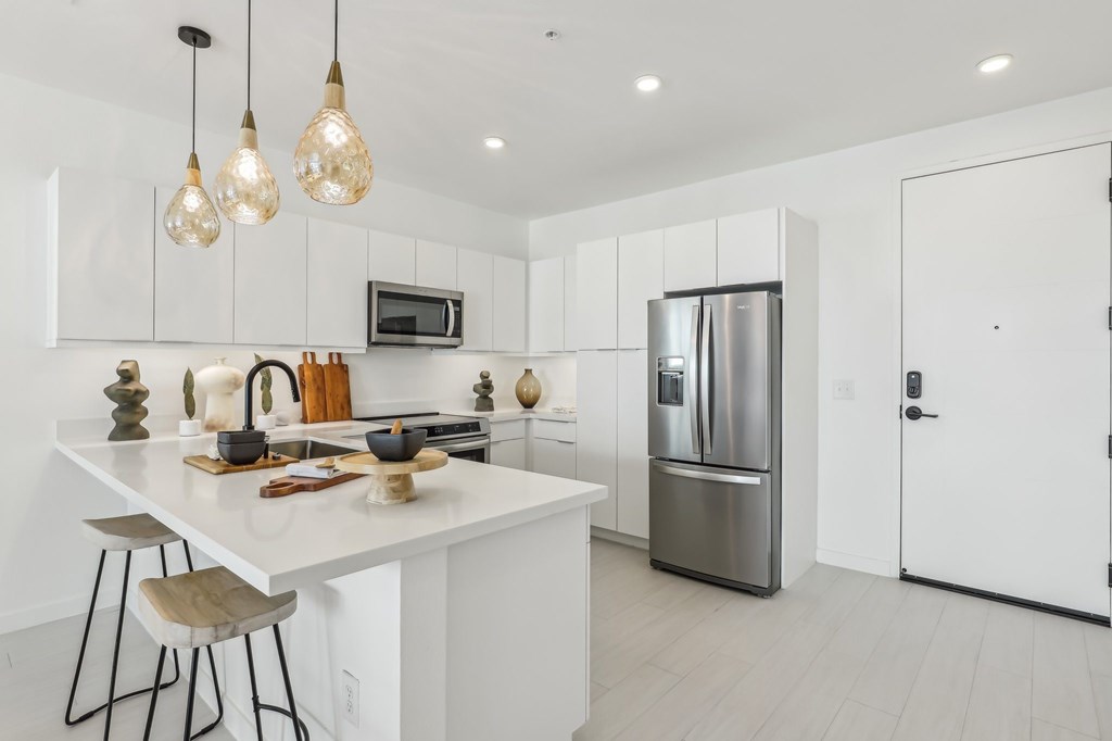 A modern kitchen with white cabinets and a white island.