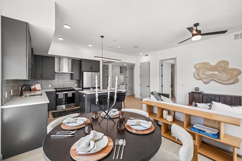 A modern kitchen with a dining table set for two.