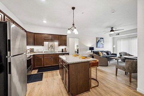 A modern kitchen with dark wood cabinets and a black refrigerator.