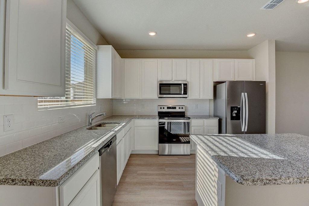 a kitchen with granite counter tops and stainless steel appliances