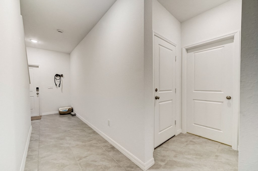 Boatman Hammock Townhomes in Lake Worth, FL photo of  a white hallway with two doors and a toilet in the corner