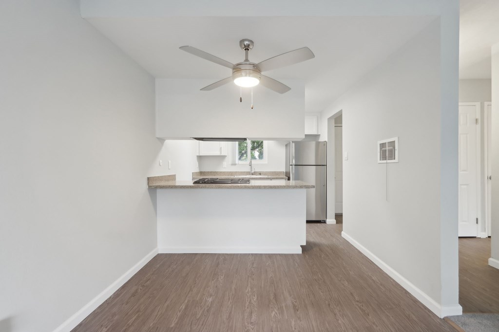A room with a ceiling fan and a counter.