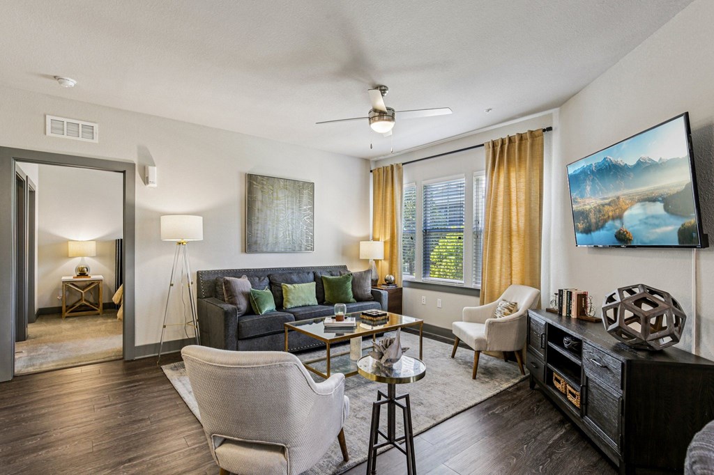Open living room with ceiling fan, natural light, and comfortable seating at Lotus at Starkey Ranch in Odessa, Florida.