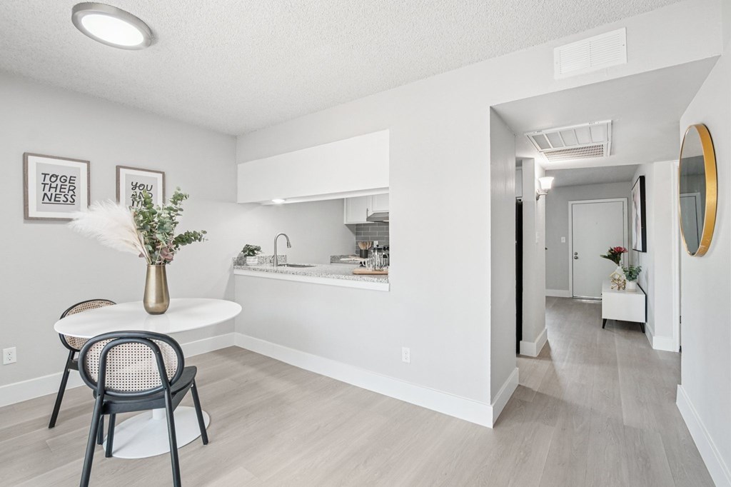 A white bathroom with a round table and chairs.
