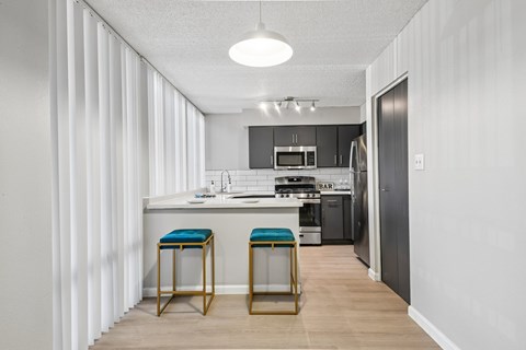 A kitchen with a bar stool in front of it.
