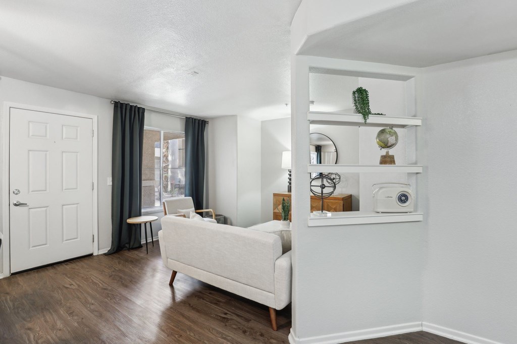 A white couch sits in a room with a white wall and a white door.