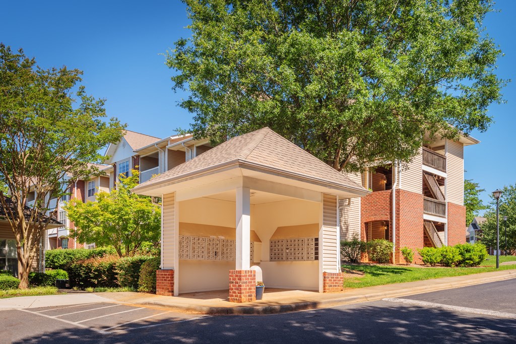 a small building with a porch in front of an apartment building