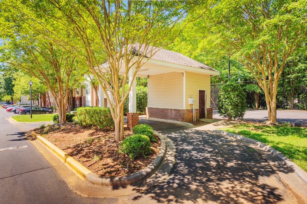 a small yellow building with trees in front of it
