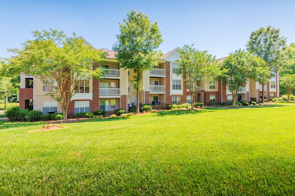 a large green lawn in front of an apartment building