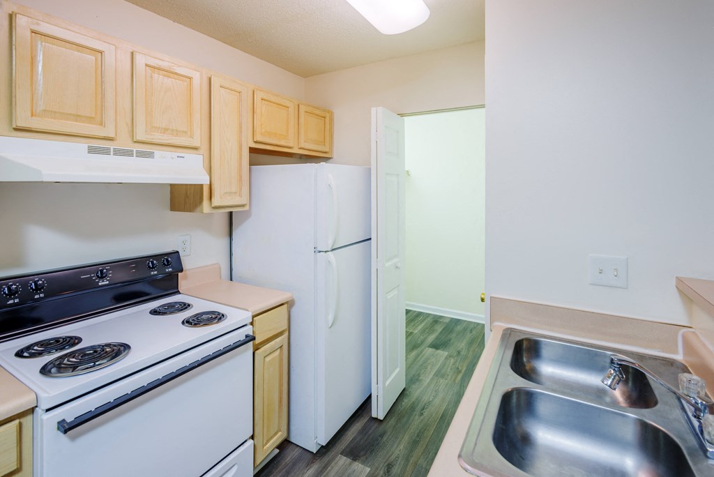 a kitchen with white appliances and wooden cabinets and a white refrigerator