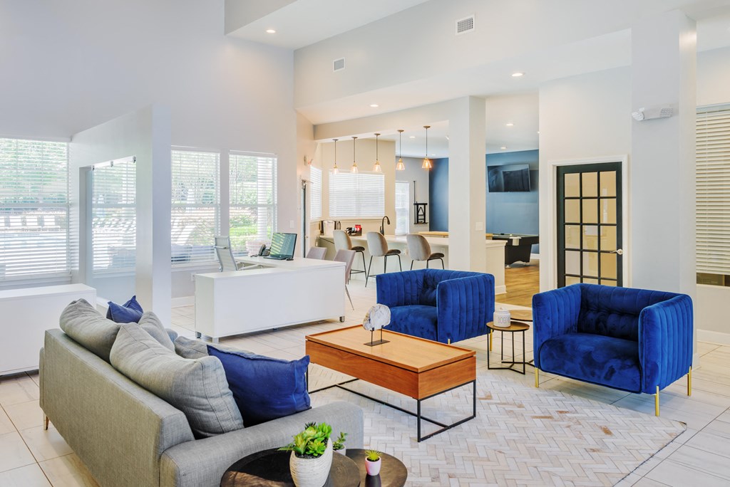 a living room with blue chairs and couches