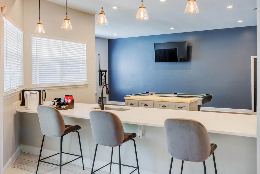 a kitchen with a bar and a pool table