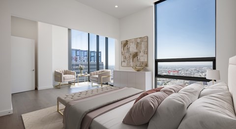A bedroom with a large bed and a view of the city.