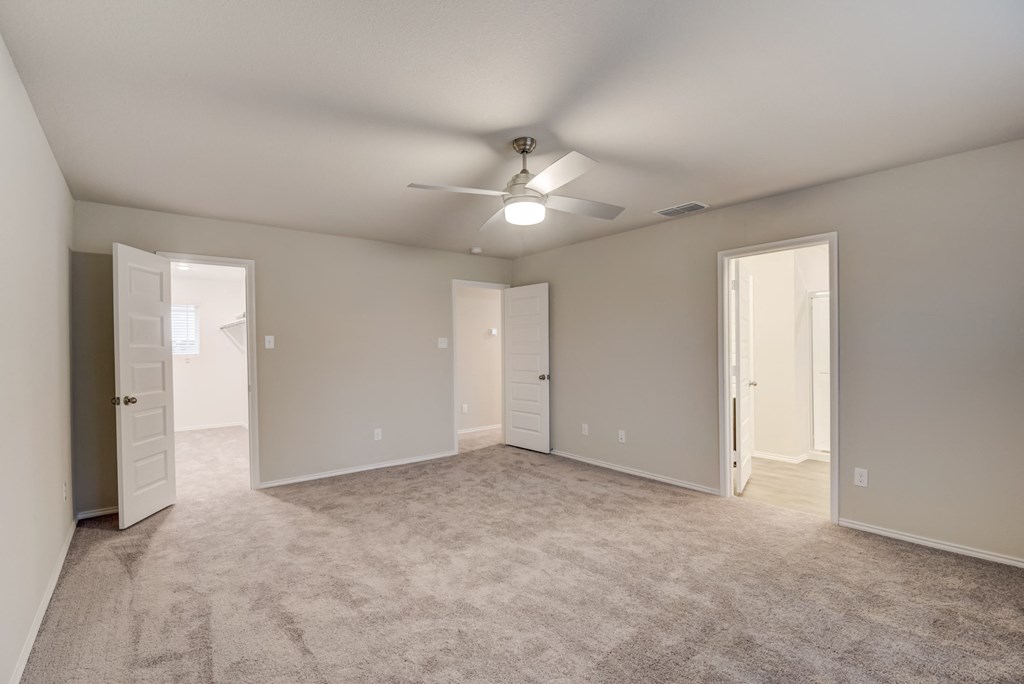 an empty living room with a ceiling fan