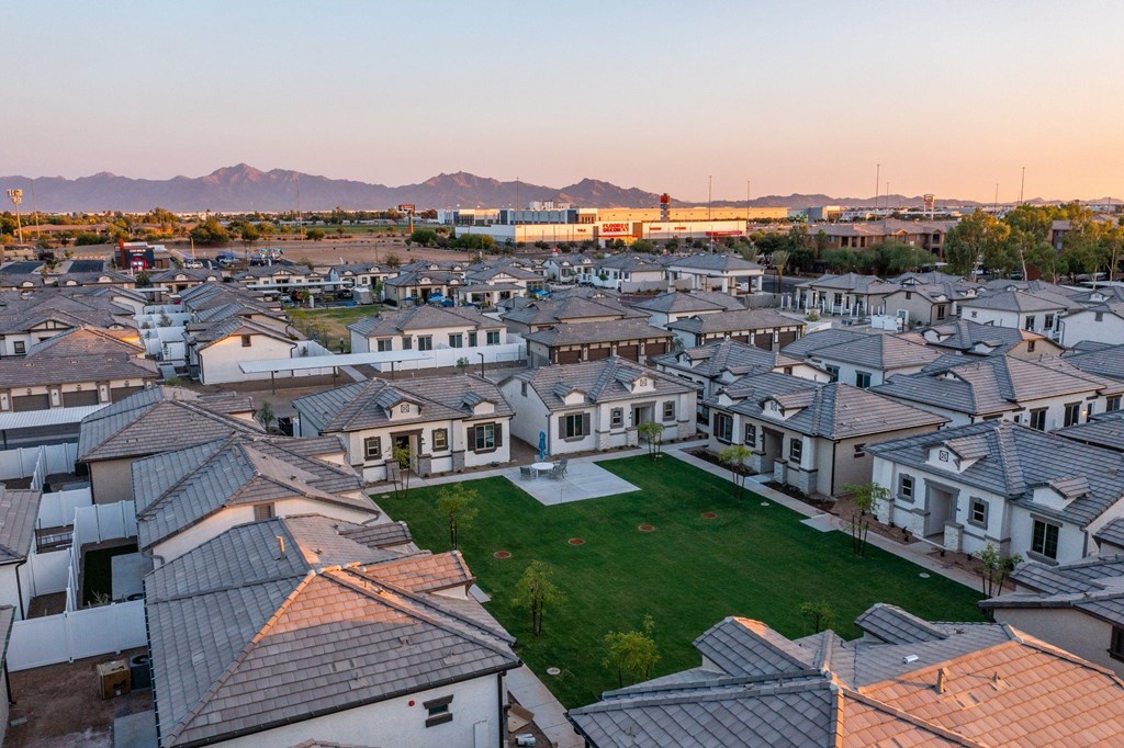 Pet-Friendly Apartments in Phoenix AZ - The Crofton at Sheely Farms - Aerial View of the Property and Community, with a Grassy Lawn in the Middle