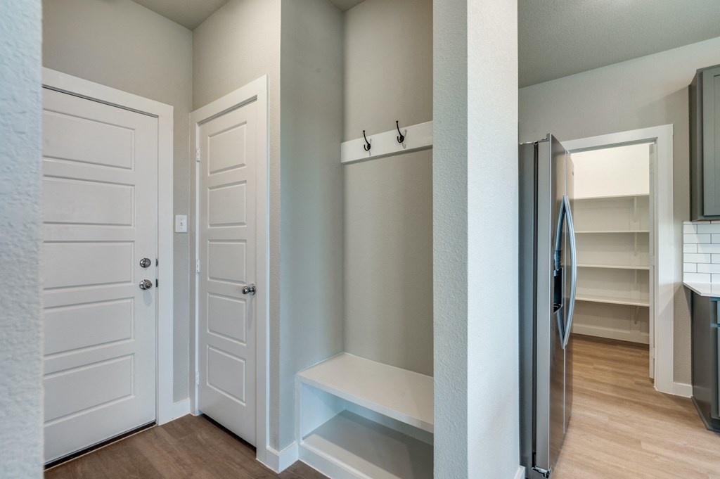 a bedroom with a closet and a hallway with a refrigerator