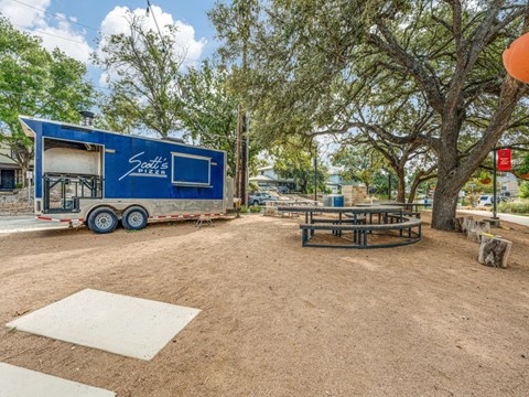 A blue trailer with the words "South's BBQ" on it is parked in a dirt lot.
