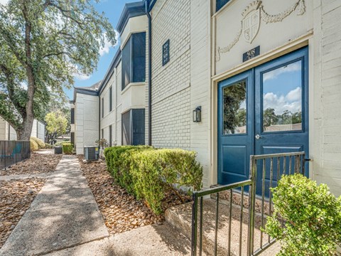 A white building with a blue door and a sign that says "307" on it.