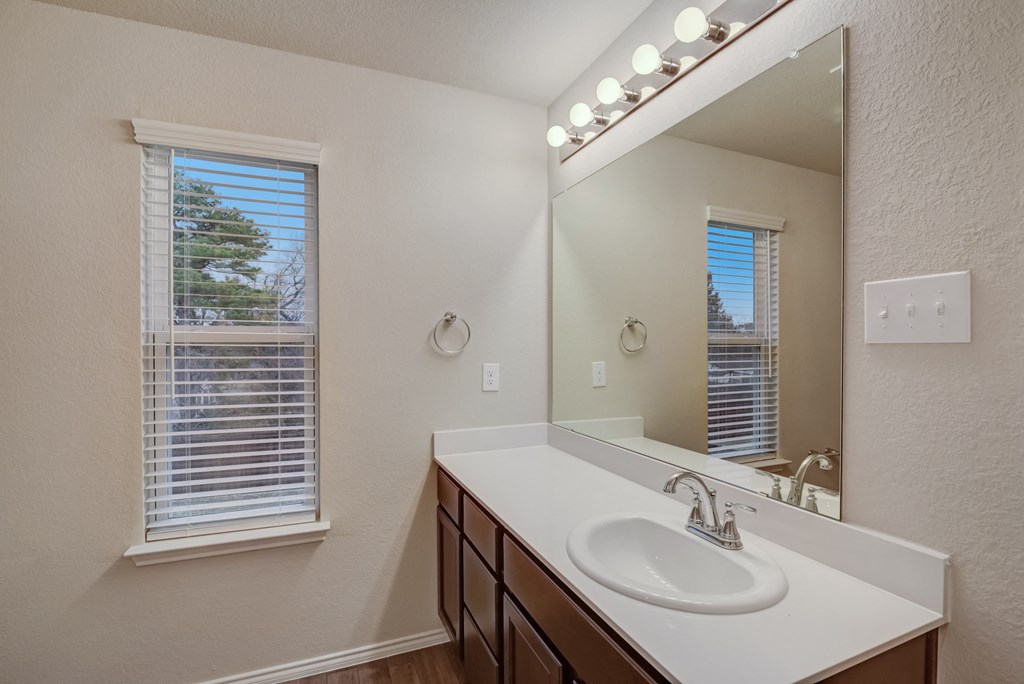 an empty bathroom with a large mirror and a sink