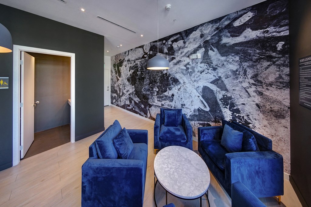 a living room with blue chairs and a white table