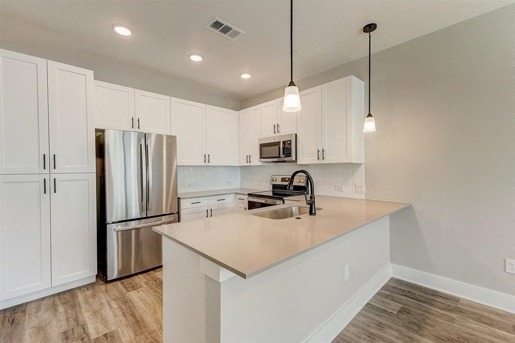 a kitchen with white cabinets and stainless steel appliances
