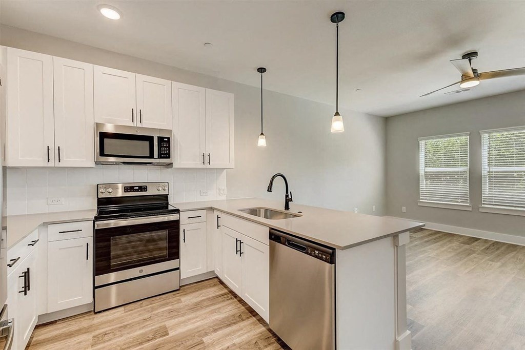a kitchen with white cabinets and stainless steel appliances