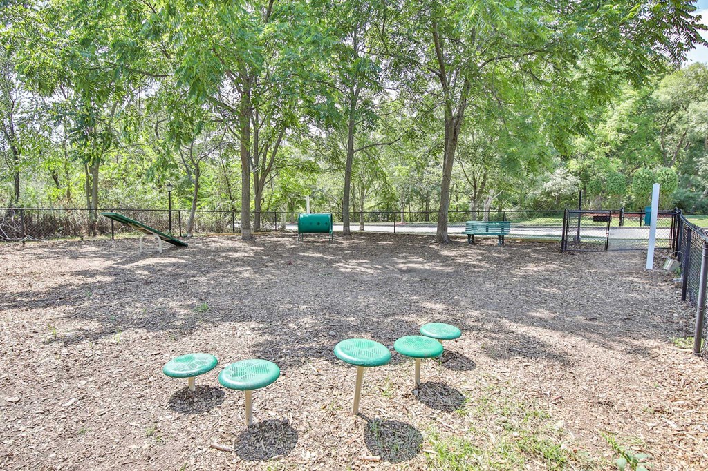 a playground with green stools in a park
