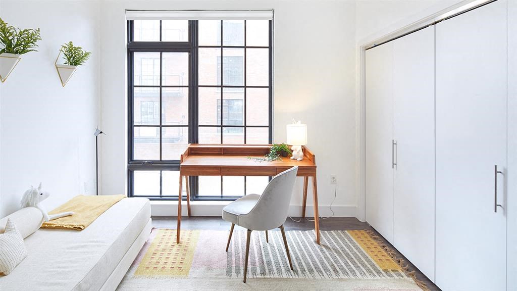 Desk and chair against window in bedroom
