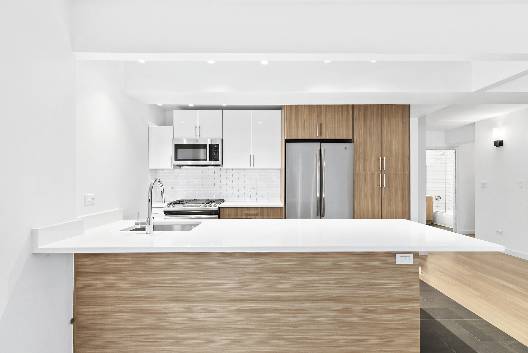a kitchen with a white counter top and a refrigerator