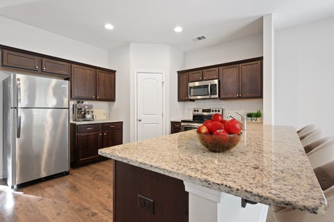 Harris Trail Luxury Townhomes for rent Richmond Hill, GA photo of a kitchen with stainless steel appliances and a granite counter top